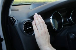 Hand checking the air conditioner in the car