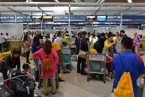 Air traveler queue at departure counter flight check for Flight Cancellations